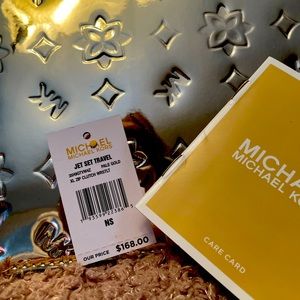 Brand new gold metallic Michael Kors wrist purse with wallet inside.
